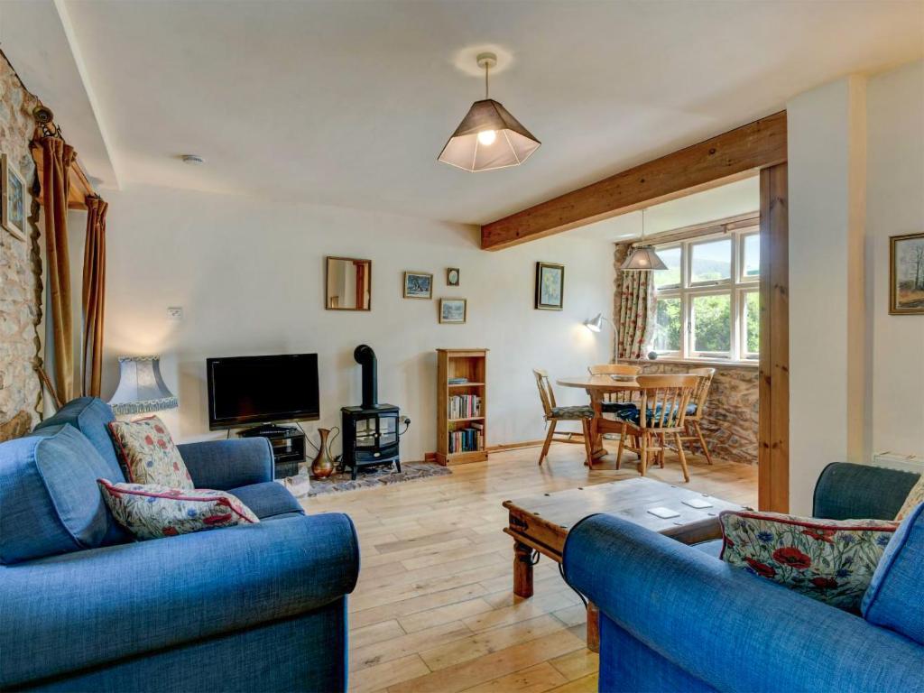 a living room with two blue couches and a table at Bossington- Ukc4921 in Timberscombe