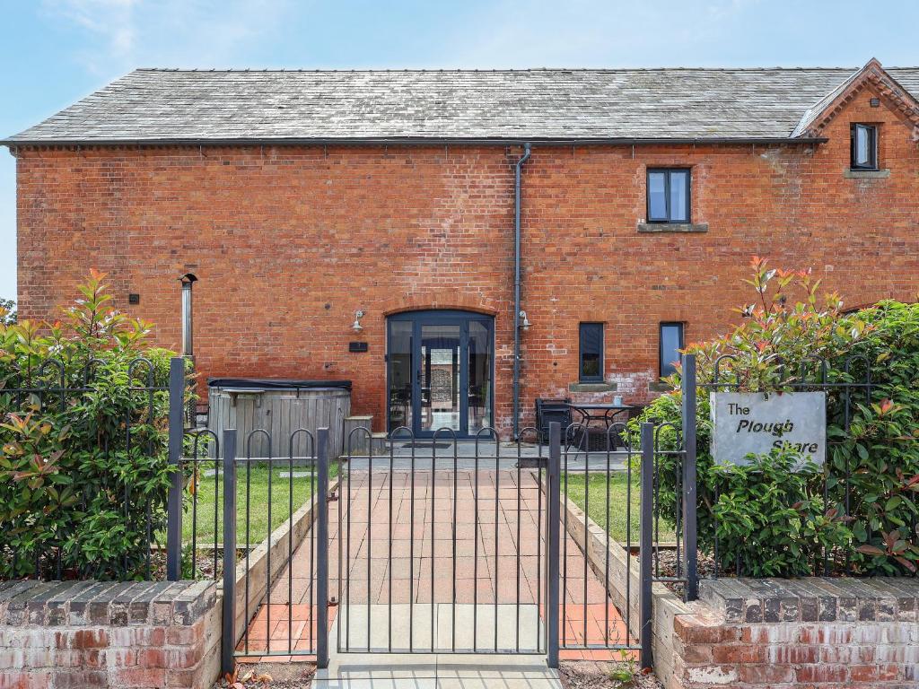 a brick building with a gate in front of it at Plough Share in Gloucester