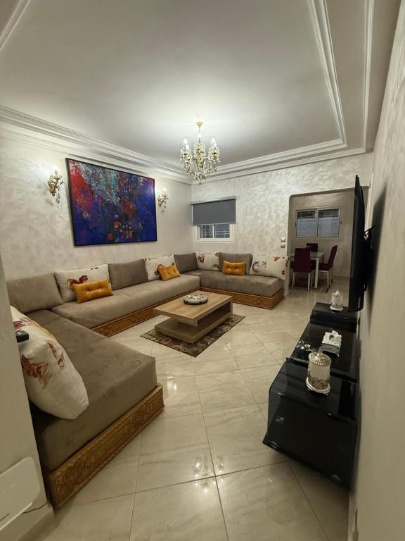 a living room with a couch and a table at Pavillon corniche Bord de mer Proche Centre in Mohammedia