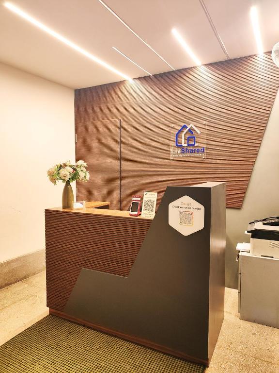 an office cubicle with a reception desk with flowers at LivShared in Patna