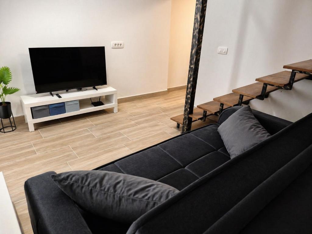 a living room with a black couch and a flat screen tv at Apartment Nero in Izola