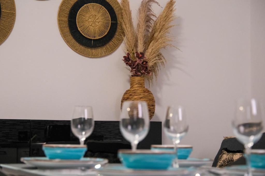 a table with wine glasses and a vase on it at Antel apartment in Naousa