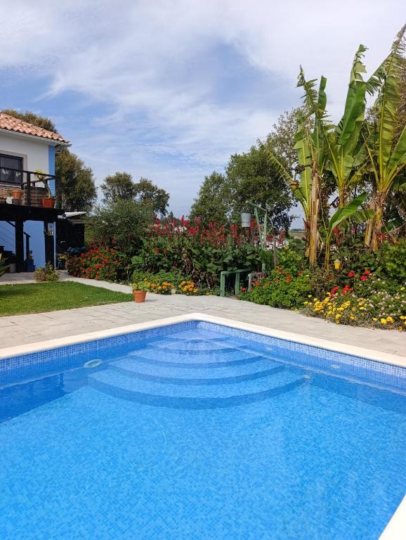 a swimming pool in front of a house at Gîte CANTO AZUL in Casal da Carreira