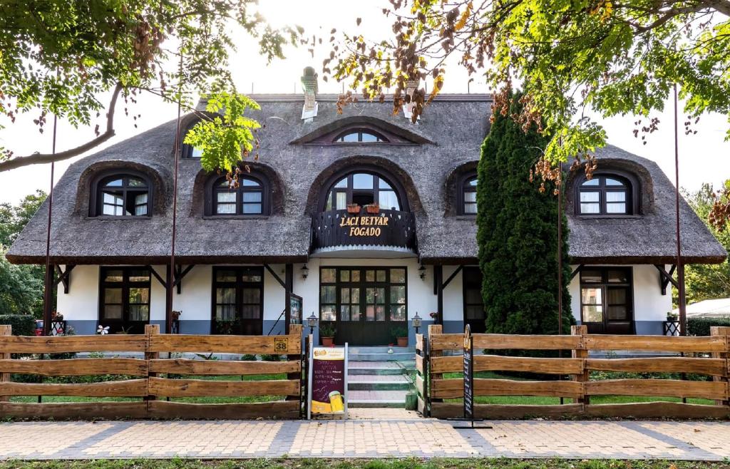 a building with a fence in front of it at Gasthof Laci Betyár in Hajdúszoboszló