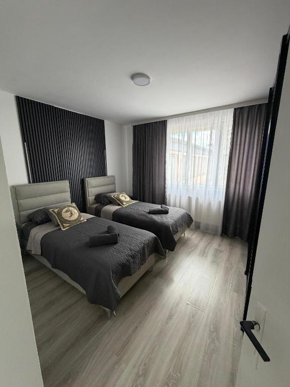 a bedroom with two beds and a window at Apartman Velić in Bor