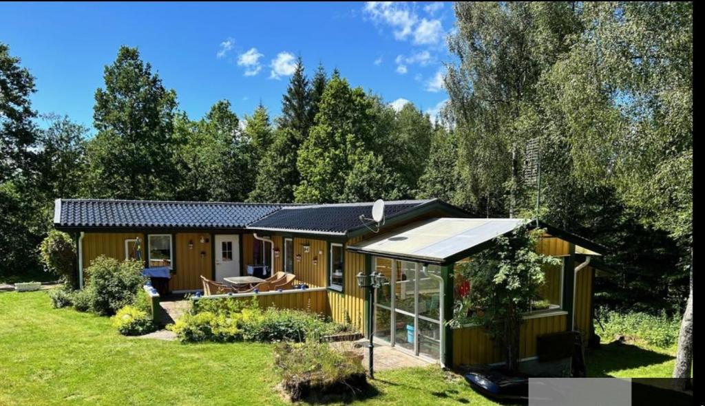 a tiny house in a garden with a solarium at Black Pearl in Höjaholm