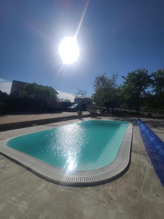 an empty swimming pool with the sun in the sky at Vila Crinul in Baile Felix