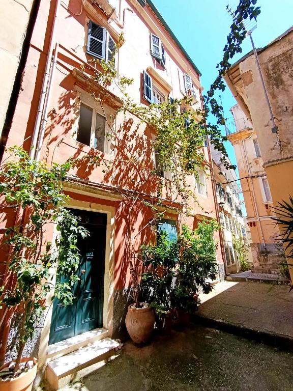 a building with potted plants in front of it at Fiore Kampielo Apartment in Corfu