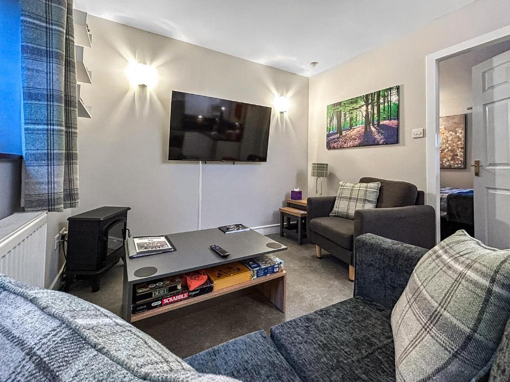 a living room with a couch and a tv at The Lade in Kilsyth