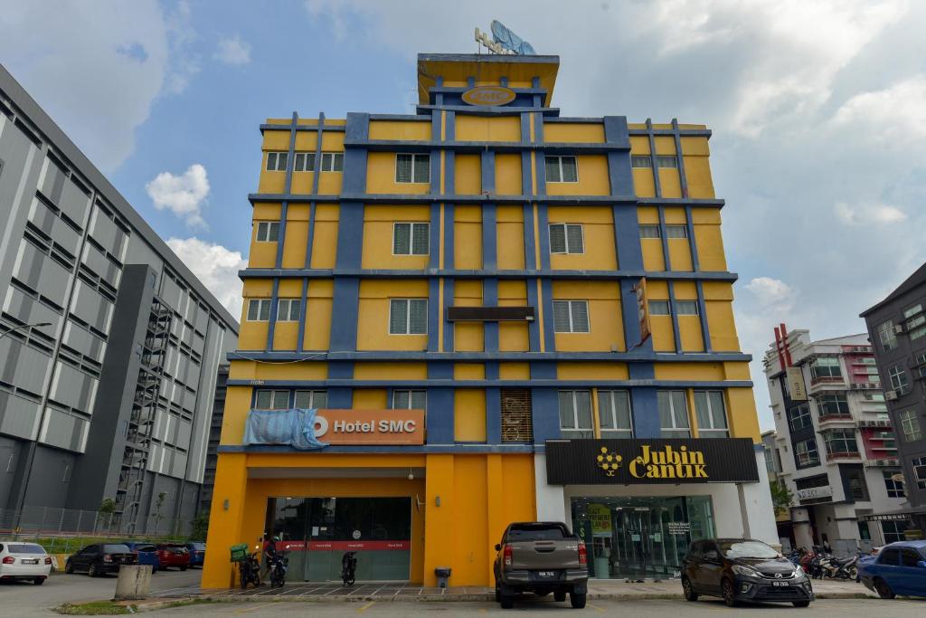 a yellow and blue building with a clock tower at SMC Hotel Alam Avenue in Shah Alam
