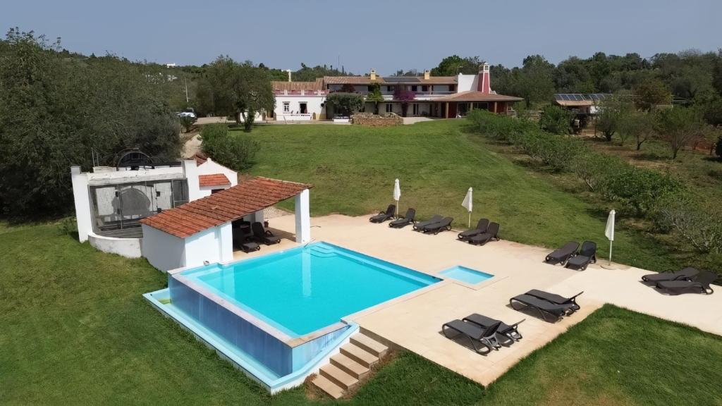 an overhead view of a swimming pool with chairs and a house at Quinta da Mesquita in Pêra