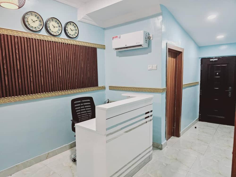 a room with two clocks on the wall and a desk at Summer Breeze Guest House in Suru Lere