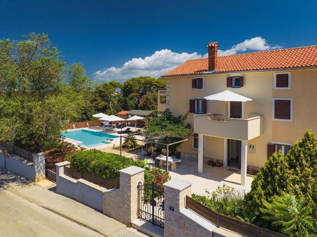 a villa with a swimming pool and a house at Apartments Borghetto in Vinkuran