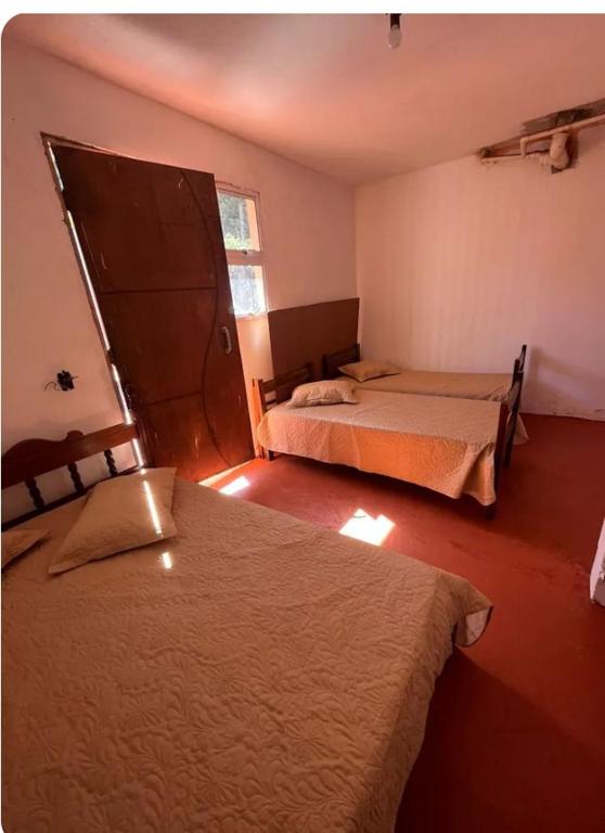 a bedroom with two beds and a window in it at Recanto da harmonia in Ribeirão Preto