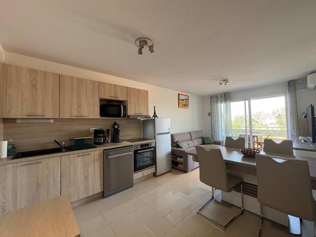 a kitchen with a table and a dining room at A 150m de la plage - Coquet appartement pour 4 personnes in Vias