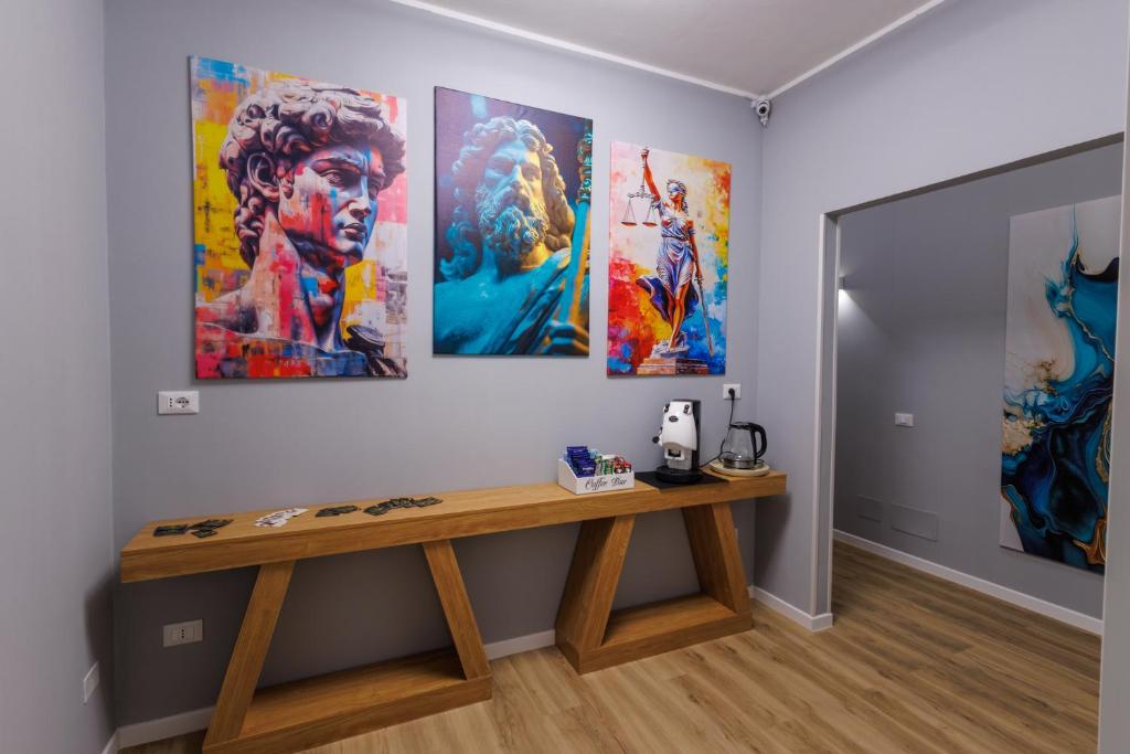 a table in a room with paintings on the wall at HARBOR BREEZE Trapani in Trapani