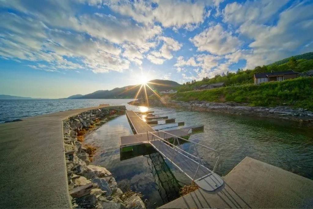 a group of benches on the shore of a body of water at Fjordheart Srbvg 1 in Hyllestad