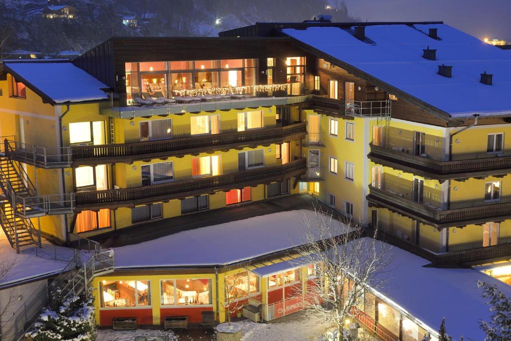 an aerial view of a hotel in the snow at night at Der Schütthof in Zell am See