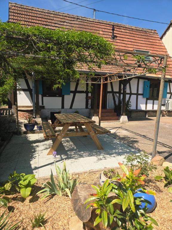 a wooden picnic table in front of a building at Cottage des potiers in Niederbetschdorf
