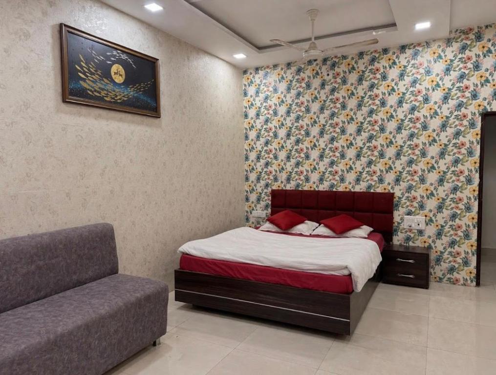 a bedroom with a bed and a couch at Hotel Tushar in Ahmedabad