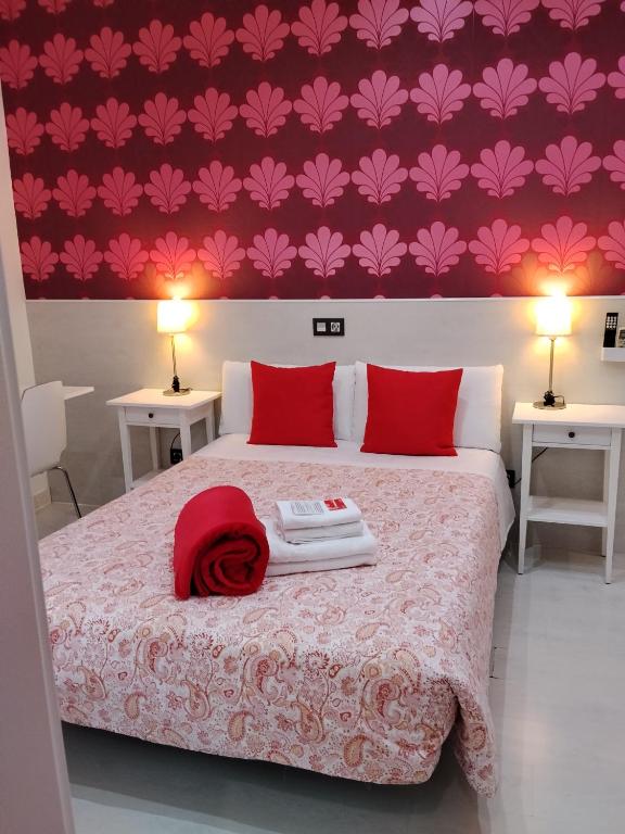a bedroom with a bed with a red towel on it at Hostal Inn Madrid in Madrid