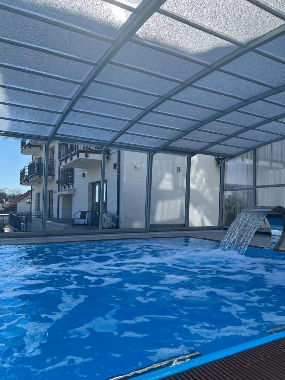 a large swimming pool with a roof over it at Przystań Admiralska 11 in Jarosławiec