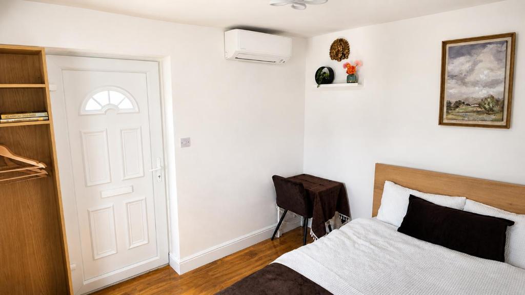 a bedroom with a bed and a white door at Corner Lodge in Eltham