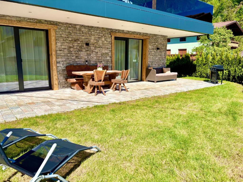 a patio with a table and chairs in a yard at Alpenchalet Oetztal in Oetz
