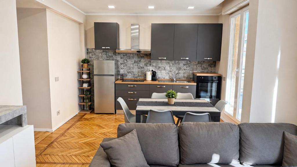a kitchen with a couch and a table with chairs at Attico Matteotti Sanremo Luxury Terrace Apartment in Sanremo