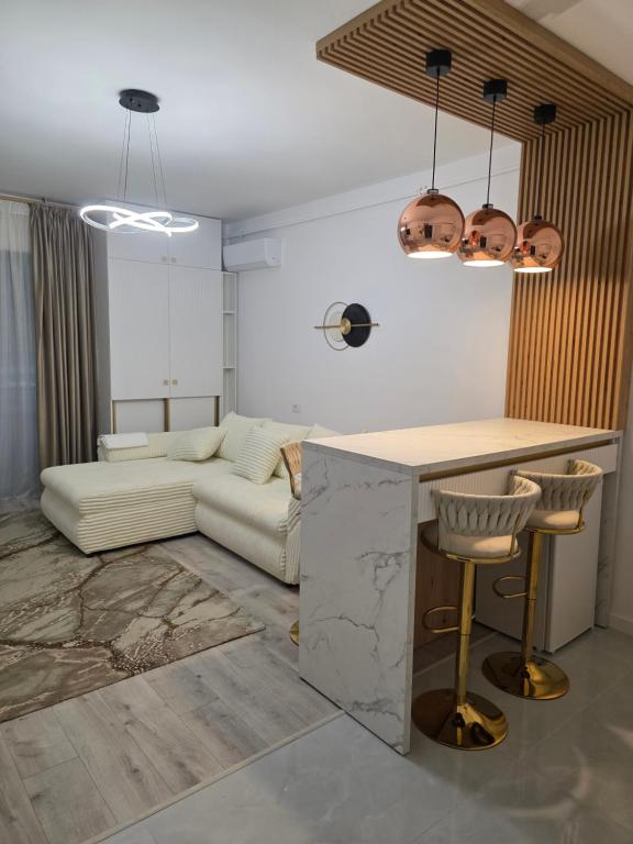 a living room with a white couch and a table at Apartament DeLux cu Jacuzzi Caciulata in Căciulata