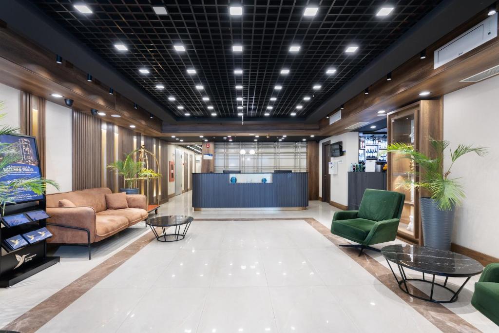 a lobby with couches and chairs in a building at Wyn Residence Batumi in Batumi