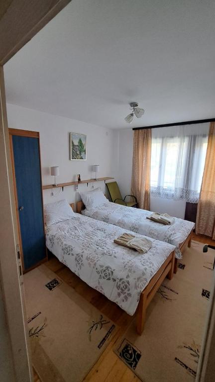 a bedroom with two beds and a blue door at Kod mosta in Pirot