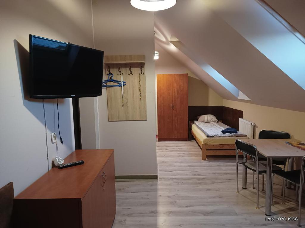 a living room with a tv and a bedroom at Apartamenty Sokółka II in Sokółka