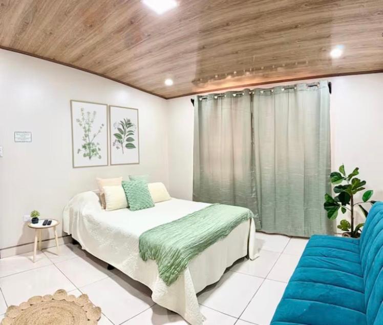 a bedroom with a bed and a large window at Apartamento H González #12 in Alajuela