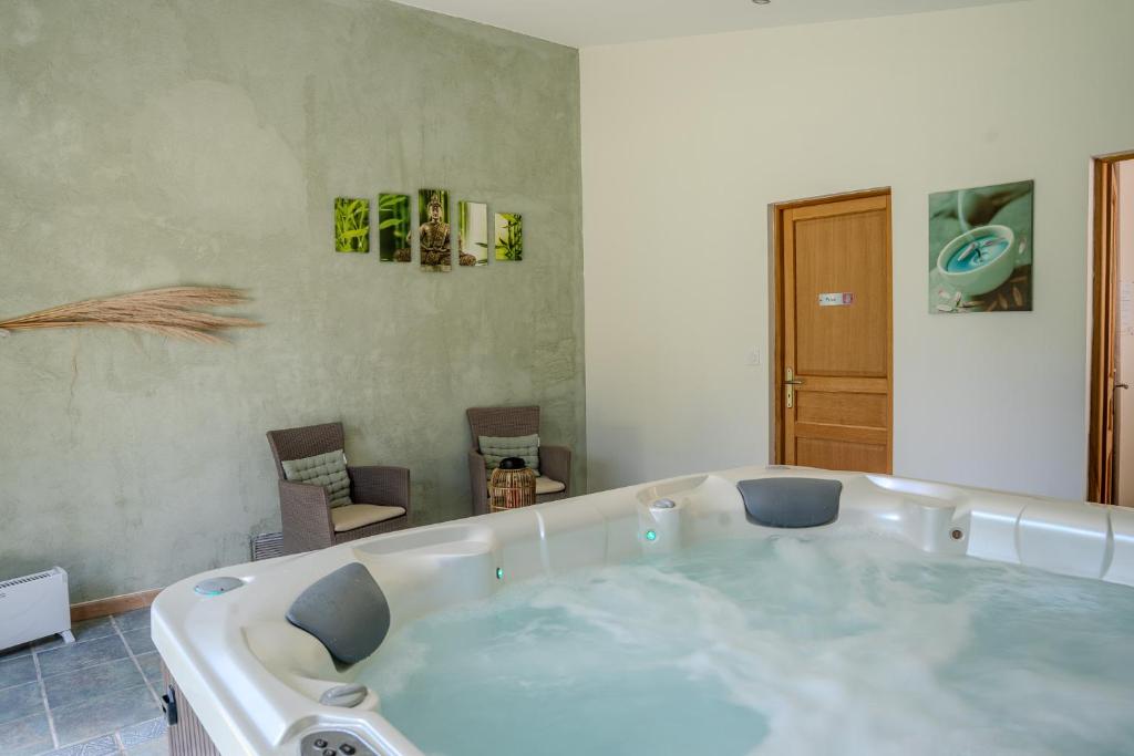 a bath tub with two chairs in a room at Logement charme provençal in Cabannes