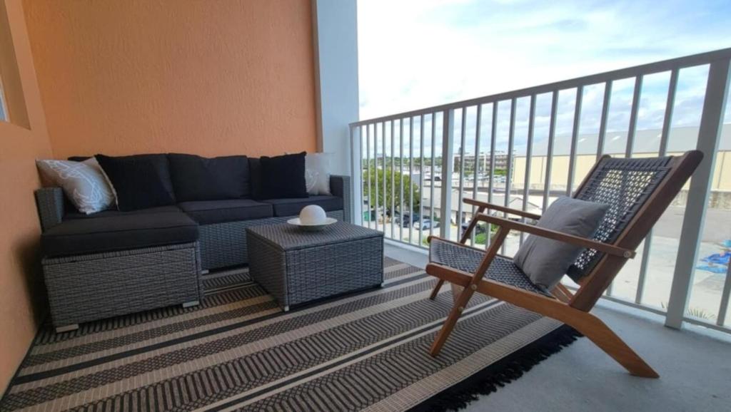 a living room with a couch and a chair on a balcony at Turnkey Tranquility with Marina & Intercoastal views in Lantana