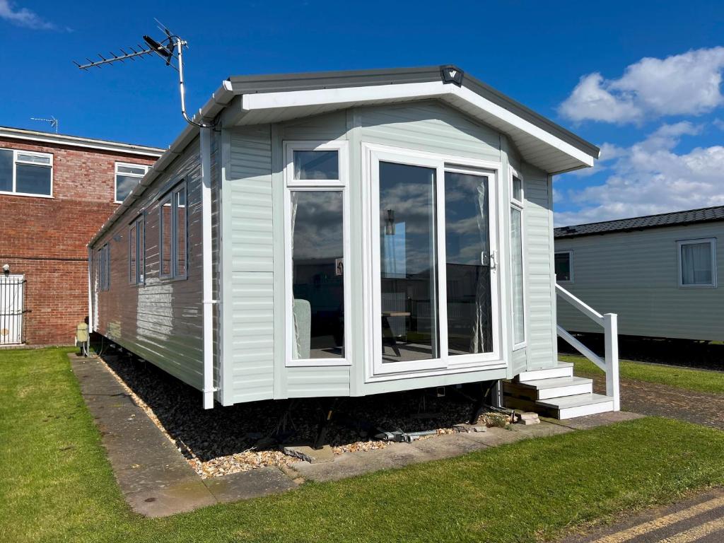 a small white shed with a large window at Merryfield and Sandfields in Chapel Saint Leonards