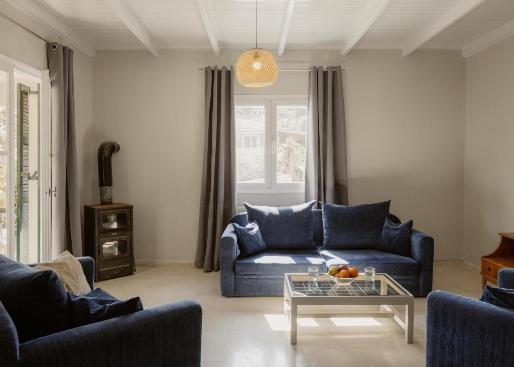 a living room with a blue couch and a table at Mediterranean Haven in Paleokastritsa