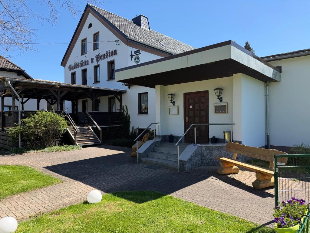 a building with a bench in front of it at Pension & Gaststätte Bauernstube in Heinsdorfergrund