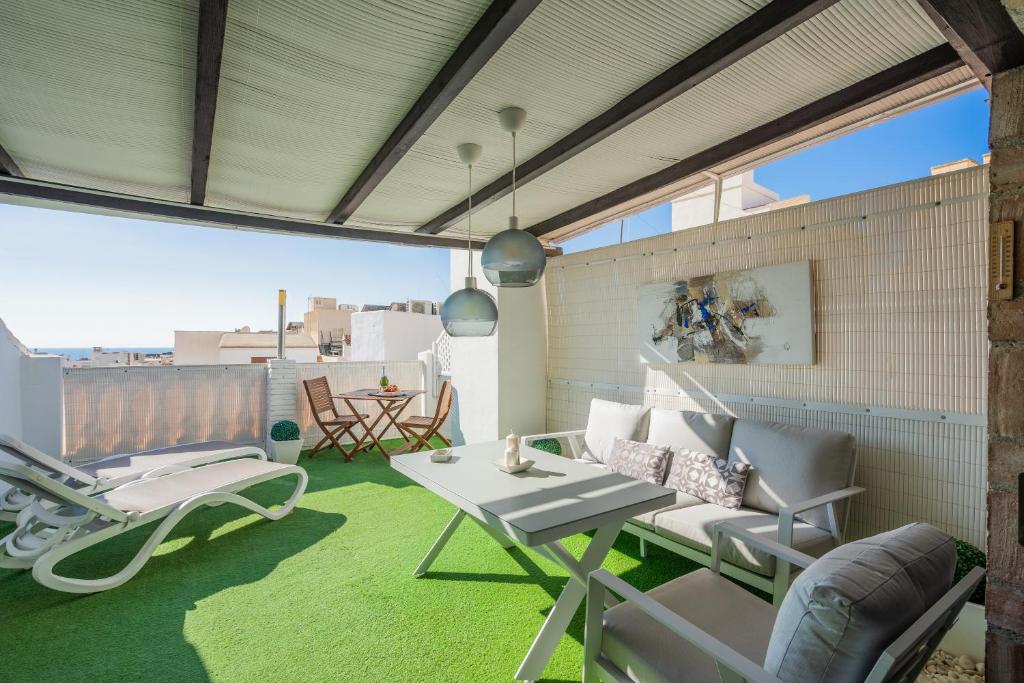 a patio with a table and chairs on a balcony at Sunny Studio Nerja in Nerja