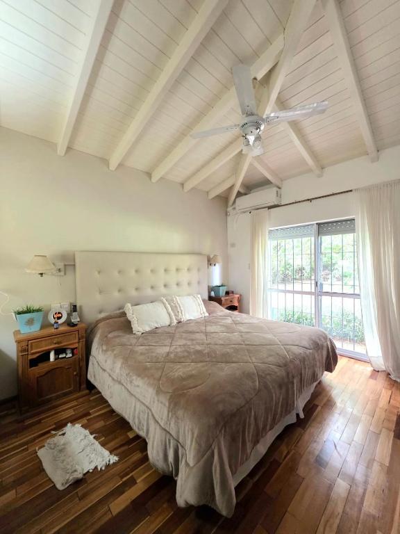 a bedroom with a large bed and a ceiling fan at Los robles suite in San Pedro