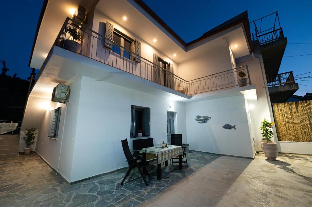 a white house with a table and a balcony at Luxury Villa Yvonni in Poros