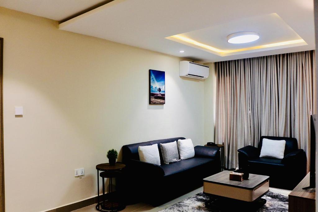 a living room with two chairs and a couch at House 10 Apartments in Abuja