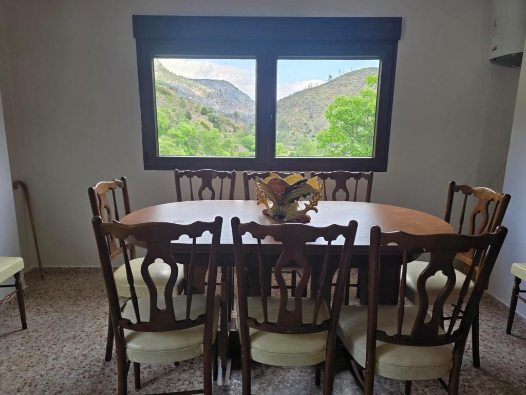 a dining room table with chairs and a window at Casa Bajo Castillo in Montán