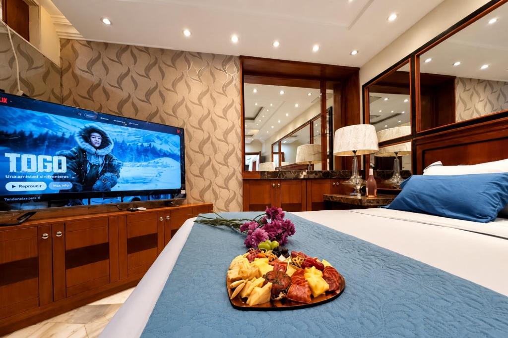 a hotel room with a plate of food on a bed at EXECUTIVE SUITE Piscina & Parking Privado in Machala