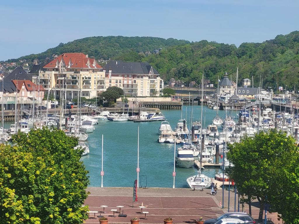 a marina with boats in the water and buildings at Escapade Romantique- Vue Port et Balcon Ensoleillé in Dives-sur-Mer