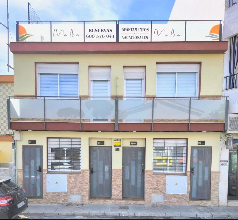 a building with a balcony on top of it at Apartamentos vacacionales malba Bajo A in Punta Umbría