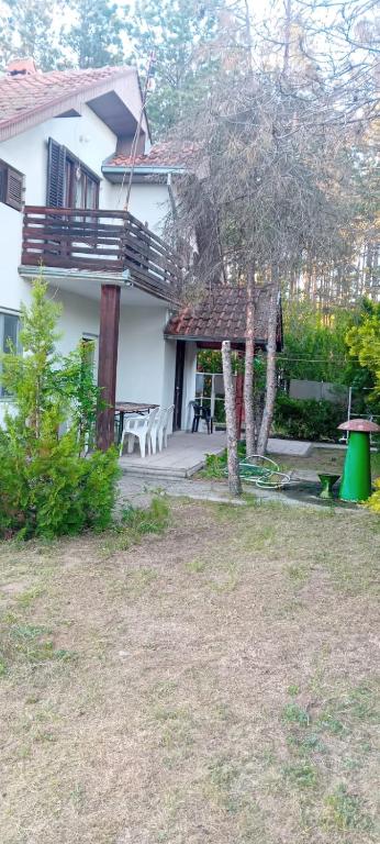 a house with a patio with chairs and a tree at Vila Sofija in Vinci