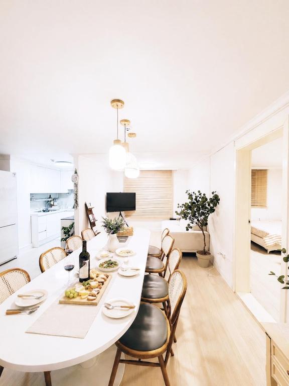 a white dining room with a white table and chairs at stay young in Suwon