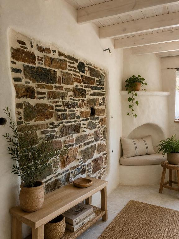 a living room with a stone wall and a table at Palokastro House Quiet Village Stay with Terrace in Samos